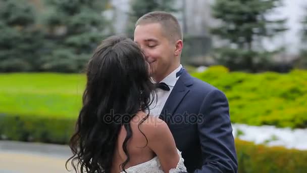 Γαμπρός και νύφη εντάχθηκε σε ένα φιλί. Η κάμερα πετάει τους. αργή κίνηση — Αρχείο Βίντεο