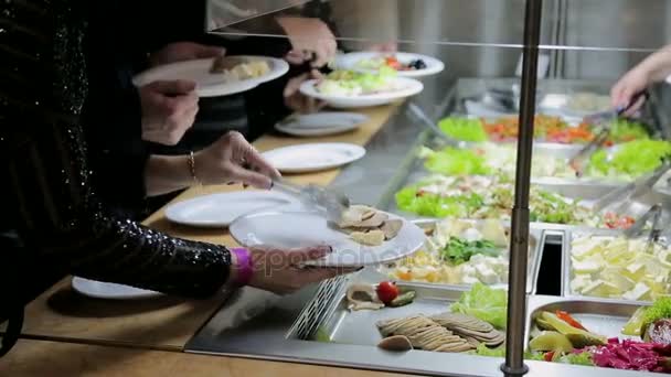 Mensen leggen voedsel. Catering. Salade leggen. Levensmiddelen distributie tabel. — Stockvideo