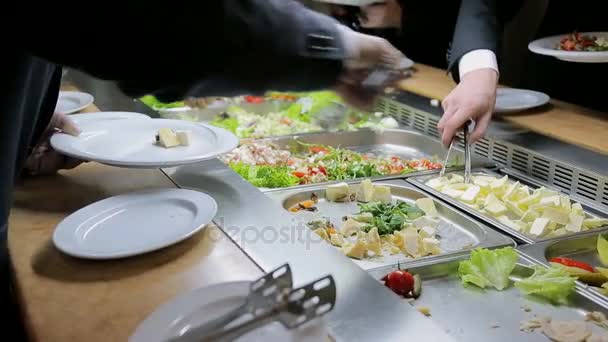 Menschen zwingen Lebensmittel auf. Catering. Salat aufsetzen. Essensausgabe. — Stockvideo