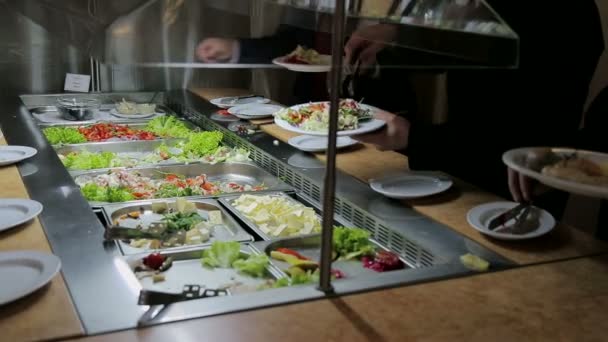 Mensen leggen voedsel. Catering. Salade leggen. Levensmiddelen distributie tabel. — Stockvideo