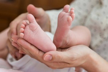 Yavaşça Bebe ayak aşağıdan holding üst eller