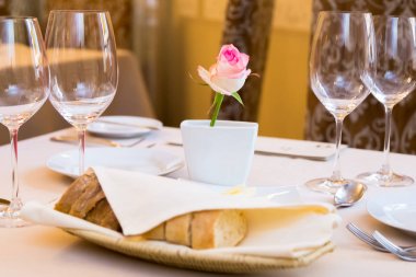 Güzel dekore edilmiş restoran tabloda. Pembe Gül desenli vazo tablodur