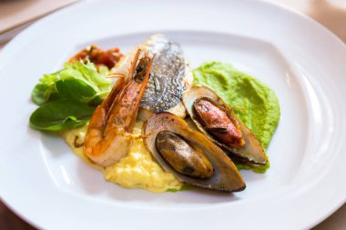 Beyaz bir plaka üzerinde deniz ürünleri. Midye ve karides balık ve yeşil