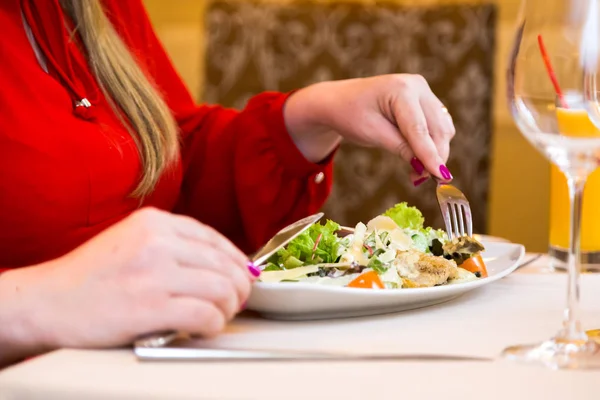 Kırmızılı kadın doğal salata yiyor. Sağlıklı beslenme ve diyet