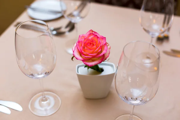 Masa dekorasyonu olarak bir vazoda pembe gül. Tablo ayarı
