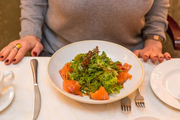 연어와 그린 샐러드를 먹는 여자. 자연 식품 및 건강 한 식습관 — 스톡 사진