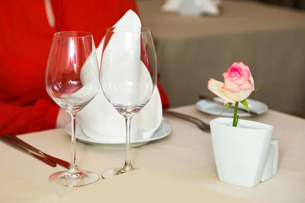Durk in rosso sta aspettando al ristorante. Servizio tavola con posate e calici di vetro al ristorante prima . — Foto Stock