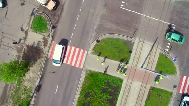 Группа людей собралась в зеленой форме, чтобы помочь людям перейти дорогу . — стоковое видео