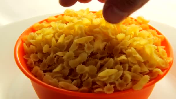 Closeup ruka je těstoviny s orange mísa otočení. Video potraviny 360 — Stock video