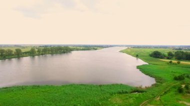 Aeria 4k. Bulutlu bir günde geniş bir nehir üzerinde uçuş