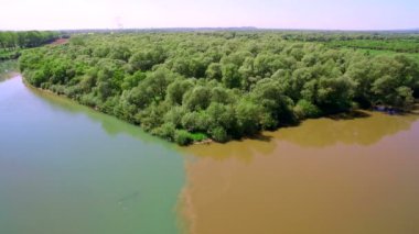 İki nehir su farklı renkteki bir büyük nehre birleştirme. Havadan görünümü 4k. Uçan güzel Nehri. Hava kamera çekim. Manzara panorama.