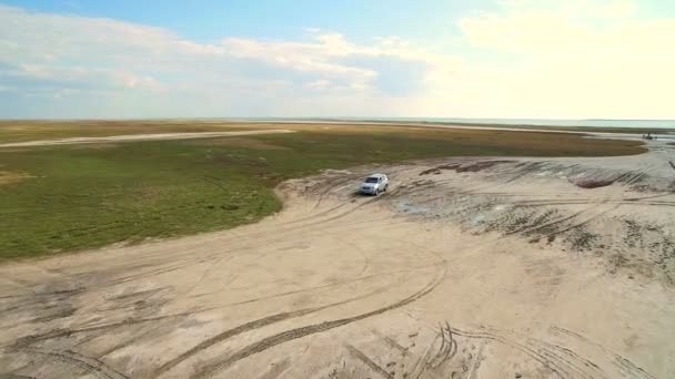 Luchtfoto schot 4k. Jeep rijdt via het moeras. Luchtfoto van de dode zee in Oekraïne. Landschap en rijkdom van de zee — Stockvideo