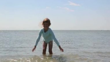 Küçük bir kız deniz suyu keyif alıyor