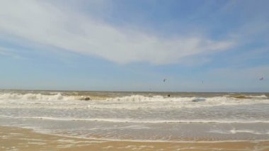 Kitesurfing. Kuzey denizin dalgaları kumlu bir plaj üzerinde alınır. Arka plan deniz