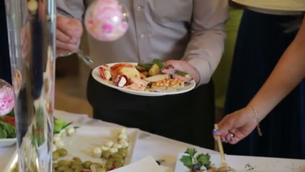 Människor införa mat. Catering. Införa sallad. Mat Distribution tabell. — Stockvideo