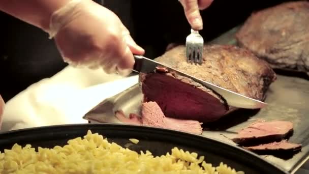 El camarero rebanando carne en guantes en el restaurante . — Vídeos de Stock