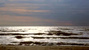 Denize yakın tutun. İnsanlar akşam gün batımında sahilde yürüyüş. Hollanda'nın Kuzey Denizi