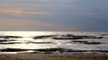 Denize yakın tutun. İnsanlar akşam gün batımında sahilde yürüyüş. Hollanda'nın Kuzey Denizi