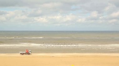 Arabayı plaj boyunca taşır. Plaj temizleme. Hollanda, Zandvoort