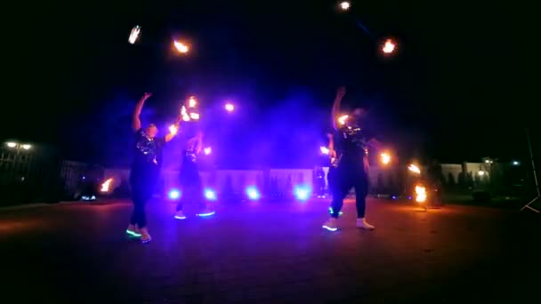 Fire show. En grupp av professionella konstnärer utför en mängd olika brand faciliteter. Pojkar och flickor utförs danser med eld i natten på gatan i parken — Stockvideo