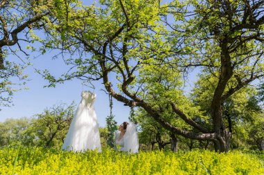 Harika bir gelin parkta salıncağa oturur ve gelinlik görünüyor