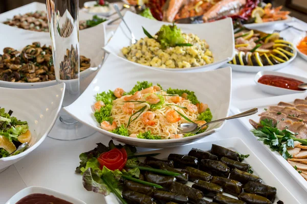 Massa com camarões em uma placa branca em uma mesa de banquete — Fotografia de Stock