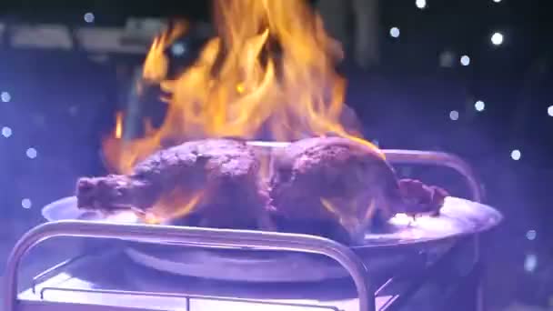 El chef profesional prepara una comida en el restaurante. Un pedazo de carne arde en el fuego con una bebida de alcohol . — Vídeos de Stock