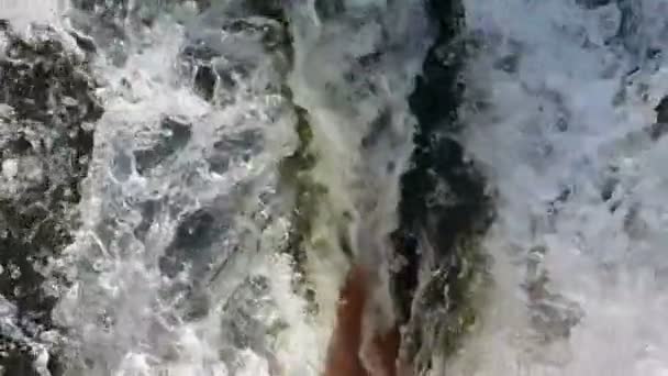 Slow-motion. Meisjes voeten in de rivier met een sterke stroming. — Stockvideo