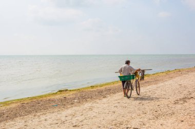 Bisikletle sahilde balık satıcı balık satıyor