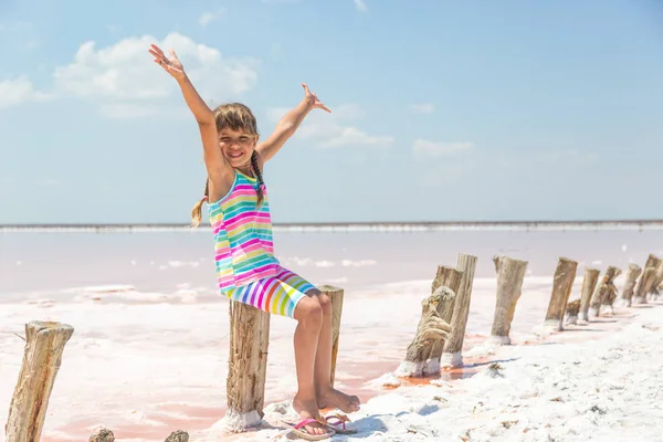 Tuz gölleri Lut ve pembe arka plan üzerinde küçük kız gül, ellerini kaldırdı
