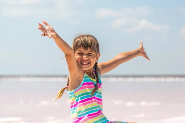 Tuz gölleri Lut ve pembe arka plan üzerinde küçük kız gül, ellerini kaldırdı