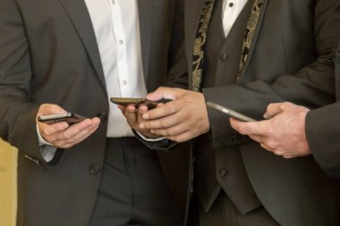 Cep telefonları ile üç iş adamları. İnsanlar çağdaş cep telefonlarıyla