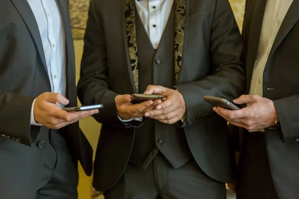 Cep telefonları ile üç iş adamları. İnsanlar çağdaş cep telefonlarıyla