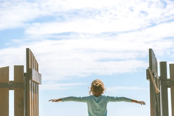 küçük kız uzak mavi gökyüzü arka planda görünüyor