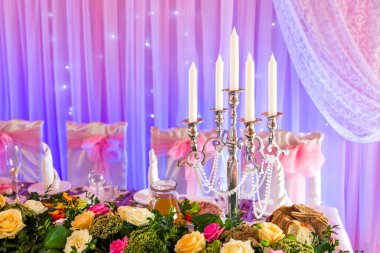 Şamdan mavi ve pembe bir arka plan üzerinde bir ziyafet masada