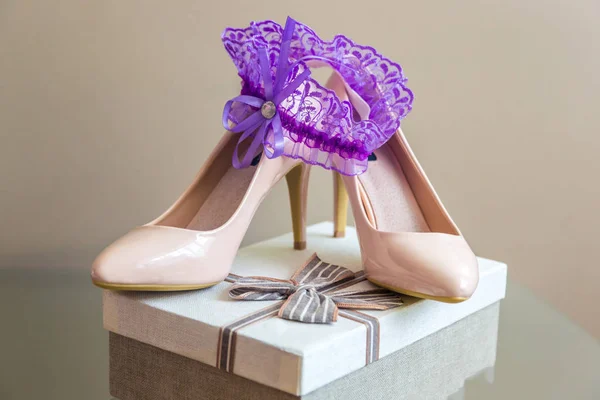 Düğün detayları. Mor jartiyer gelinler terlik üzerinde. Bir hediye kutusu