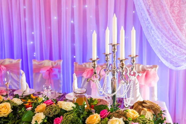 Свеча на банкетном столе на голубом и розовом фоне — стоковое фото