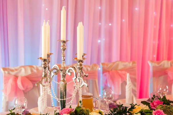 Свечи за банкетным столом в теплых розовых тонах — стоковое фото