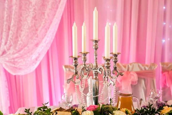 Свечи за банкетным столом в теплых розовых тонах — стоковое фото
