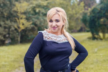 Bir parkta güzel kız model fotoğraf makinesi için poz.