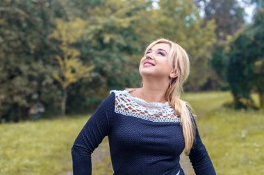 Bir parkta güzel kız model fotoğraf makinesi için poz.