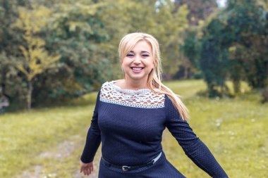 Bir parkta güzel kız model fotoğraf makinesi için poz.