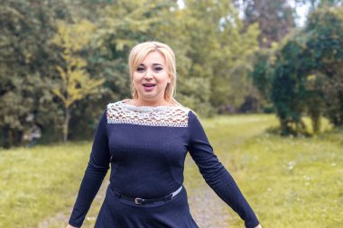 Bir parkta güzel kız model fotoğraf makinesi için poz.