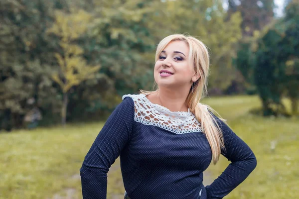 Bir parkta güzel kız model fotoğraf makinesi için poz.