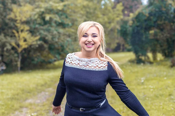 Bir parkta güzel kız model fotoğraf makinesi için poz.