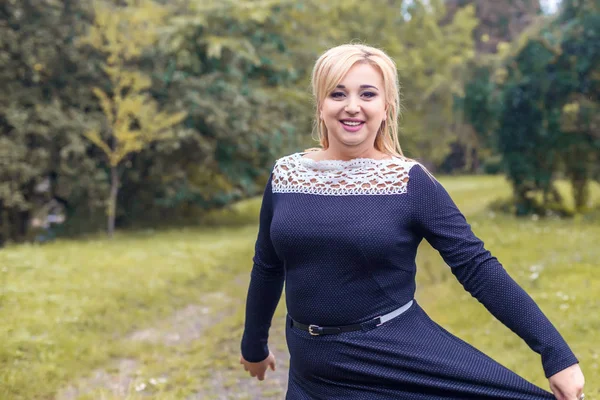 Bir parkta güzel kız model fotoğraf makinesi için poz.