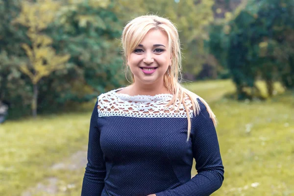 Bir parkta güzel kız model fotoğraf makinesi için poz.