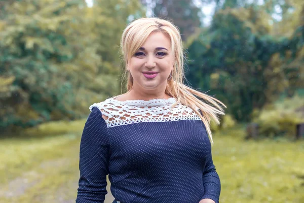 Bir parkta güzel kız model fotoğraf makinesi için poz.