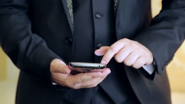 Browsing information on smart. Man uses a mobile gadget holding a phone in his hand — Stock Video