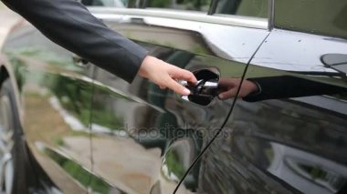 Adam yakın çekim içinde arabanın kapısını açar, arabada setleri ve kapıyı kapatır